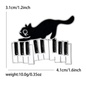 Broche en émail chat noir sur touches de piano avec strass vert, 4,1cm x 3,1cm