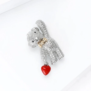 Detailed close-up of rhinestone teddy bear brooch with red heart charm and golden bow