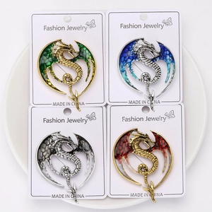 Detailed set of four dragon brooches in gold and silver tones with colorful enamel wings