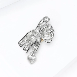 Silver bear brooch with rhinestone heart pendant and secure pin back on white background