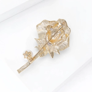 Detailweergave van de achterkant van de gouden roosbroche met speldsluiting en textuur