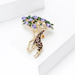 Detailed macro view of a golden giraffe brooch with purple crystals and green enamel leaves
