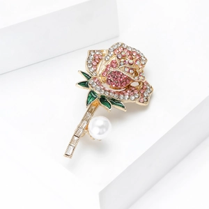 Detailopname van roosvormige broche met roze strassteentjes, emaille en witte parel