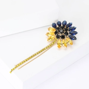 Détail de la broche tournesol avec cristaux bleu jaune et de longs glands dorés