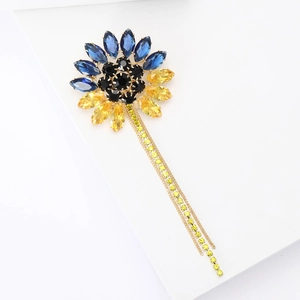 Détail de la broche tournesol avec cristaux bleu et jaune et chaînes à pompons