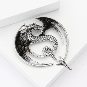 Macro shot of silver dragon brooch wings with black and white enamel drip texture detail