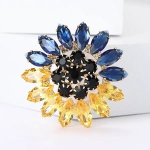 Vue détaillée d'une broche tournesol aux cristaux bleus et jaunes et alliage doré