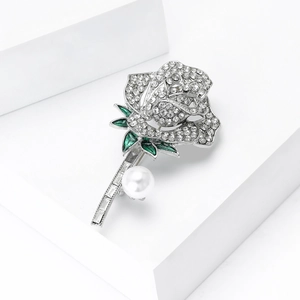 Detail van de rozenbroche met groene emaille bladeren, witte kristallen en parel