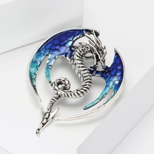 Detail of silver dragon brooch featuring blue-green gradient wings and intricate scales