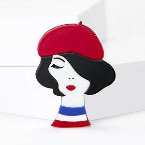 Detail view of acrylic brooch featuring a chic French woman with red beret and striped shirt