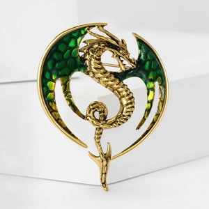Macro detail of a Western dragon brooch with green enamel wings and scales on a gold base