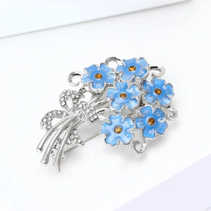 Macro shot of blue enamel hydrangea brooch with yellow rhinestones and crystal bow