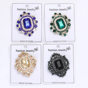 Détail de broches en cristal vintage de couleurs bleu, vert, champagne et noir élégantes