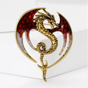 Detail of dragon brooch with red honeycomb wings and antique gold metal finish