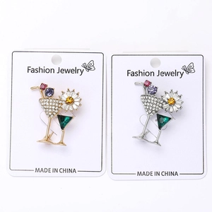 Detailed macro view of cocktail glass brooches with gold and silver bases and colorful rhinestones