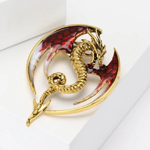 Detailed macro shot of the golden flying dragon brooch with red and white enamel wings
