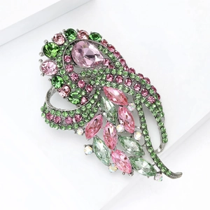 Détails macro d'une élégante broche en cristal rose et vert au design de plume