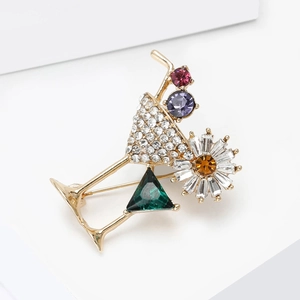 Detail showing cocktail glass brooch with sparkling crystals and a daisy floral design