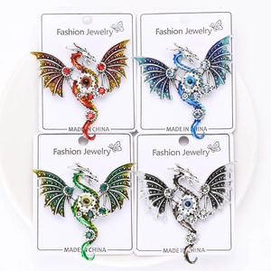 Detail of steampunk dragon brooch pins in four enamel colors with mechanical gear motifs
