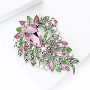Vue détaillée de la broche en cristal sur support blanc montrant le design floral rose