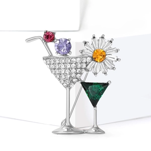 Detailed close-up of a cocktail glass brooch with sparkling rhinestones and green gem