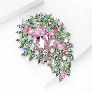 Vue macro d'une broche fleurie en cristal rose et vert avec pierre en poire