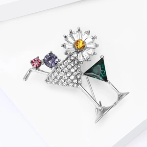Detail of cocktail glass brooch with colorful gemstones and rhinestones on white base