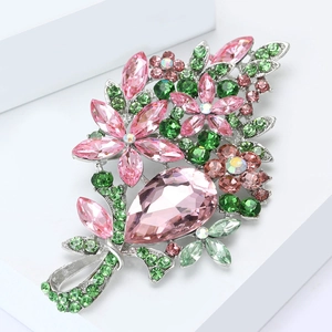 Vue macro d'une broche fleurie en cristal rose et vert avec strass en forme de poire