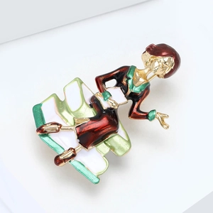 Macro shot of an elegant lady sitting on books brooch with detailed enamel coating