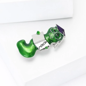 Cute green bookworm enamel brooch with graduation cap and ABC book on white steps