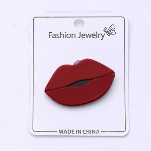 Détail de la broche lèvres rouges en acrylique sur carte pour costumes et chemises