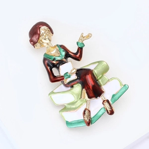 Close-up of enamel brooch showing a lady sitting on books with red beret and green dress