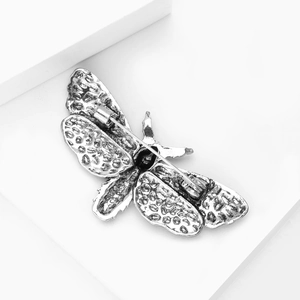 Macro view of the vintage silver moth brooch back with detailed texture and secure pin clasp