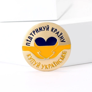 Fashionable Ukraine peace pin with blue yellow enamel heart and hands on white stand