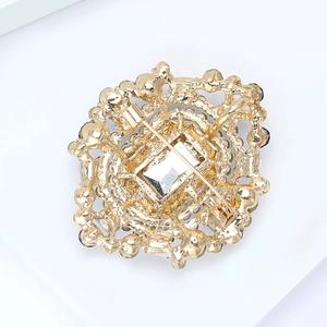 Vue détaillée de l'arrière d'une broche dorée vintage avec structure ajourée et fermoir