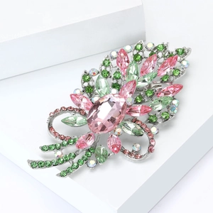 Macro d'une broche fleur avec cristaux roses et verts sur un socle géométrique