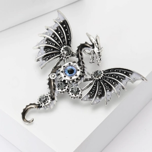 Detailed view of dragon brooch with silver-tone metal and blue eye crystal decoration