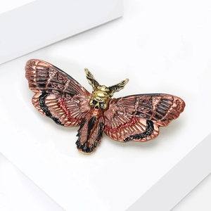 Macro shot of death's-head hawkmoth brooch with gold skull and enamel wing textures