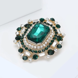 Vue macro d'une broche vintage de luxe avec pierre vert émeraude et cristaux brillants