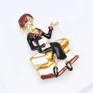 Detail of elegant teacher brooch with gold finish and enamel sitting on books