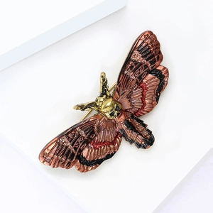 Macro view of vintage death's-head hawkmoth brooch with gold skull and enamel texture
