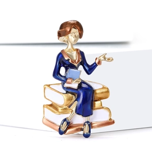 Detail of artistic enamel teacher brooch with woman figure on books with golden finish