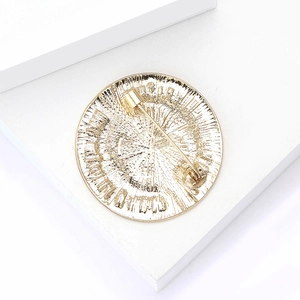 Detailed back view of a round gold metal brooch pin featuring fine radial texture