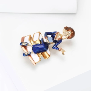 Detail of enamel teacher brooch featuring a lady reading on books with gold plating
