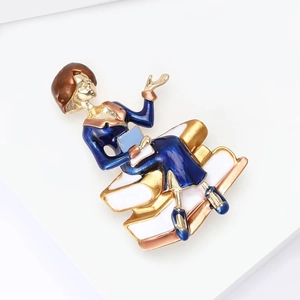 Detail view of female reader brooch with blue dress and enamel finish on gold plating