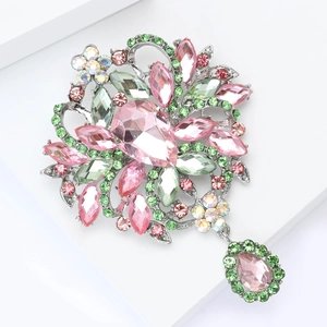 Gros plan d'une broche florale de luxe avec cristal rose et strass verts brillants
