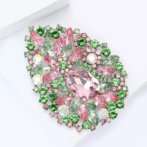 Vue détaillée d'une broche fleurie vintage avec cristal rose et pierres vertes