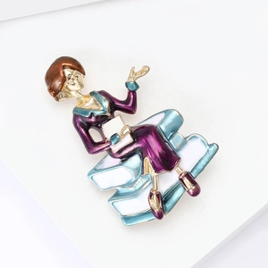 Detailed macro view of creative enamel teacher brooch with purple dress on books