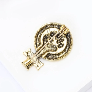 Détail macro de la broche féministe en or vintage montrant le fermoir rotatif et l'alliage