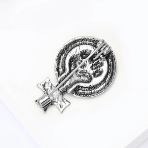 Détail macro d'une broche féministe rétro avec symbole de poing et texture en alliage